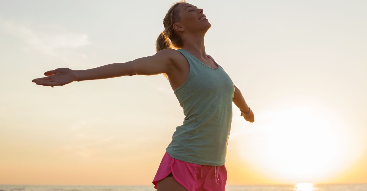 Portrait of a lady with arms extended and happy.